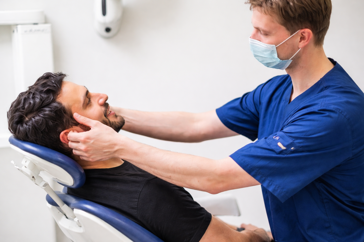 Médecin examinant le visage d’un patient lors d’une consultation en médecine esthétique