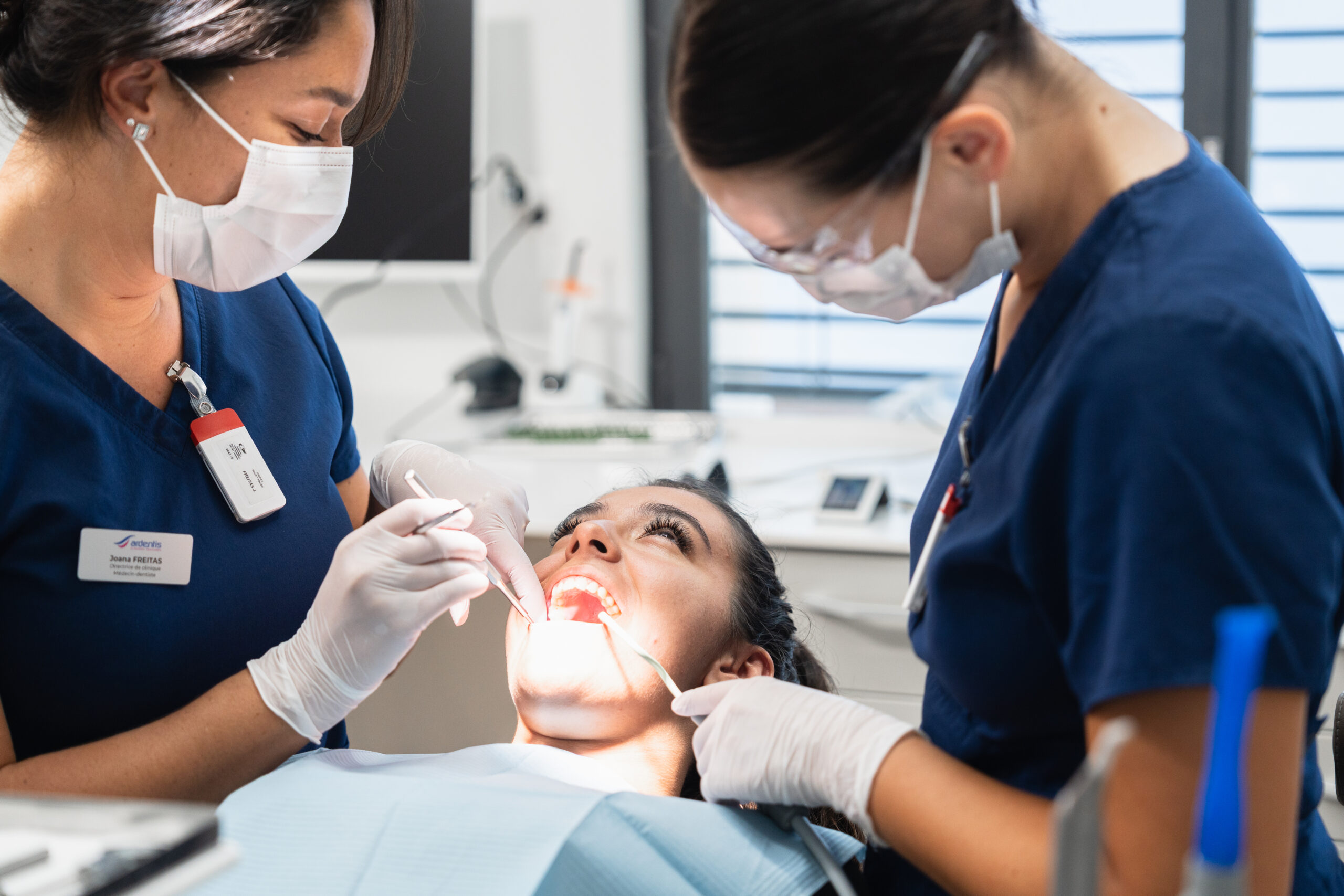 Dentistes prenant en charge une patiente en salle de soins après une intervention buccale