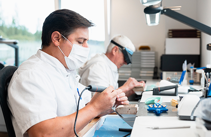 Technicien dentaire fabriquant une prothèse dentaire en laboratoire