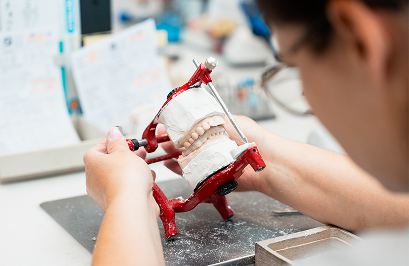 Technicien dentaire travaillant sur un modèle dentaire pour un appareil orthodontique
