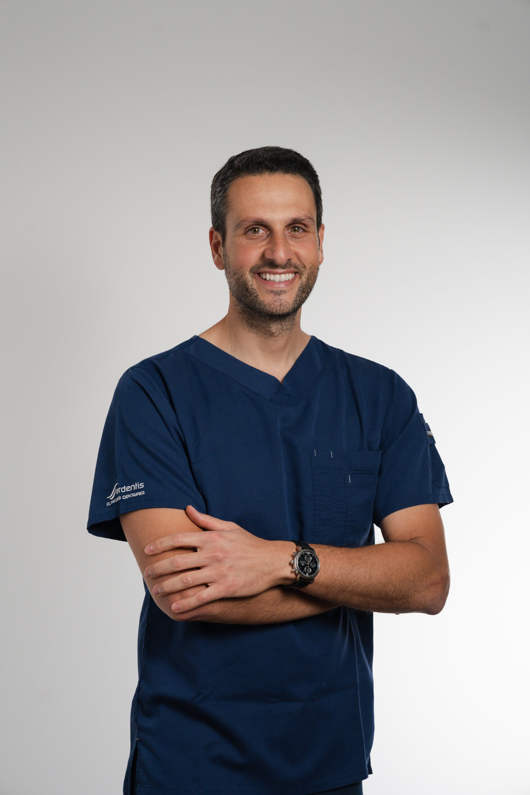 Dr Nicolas Kardous, dentiste en tenue médicale bleue